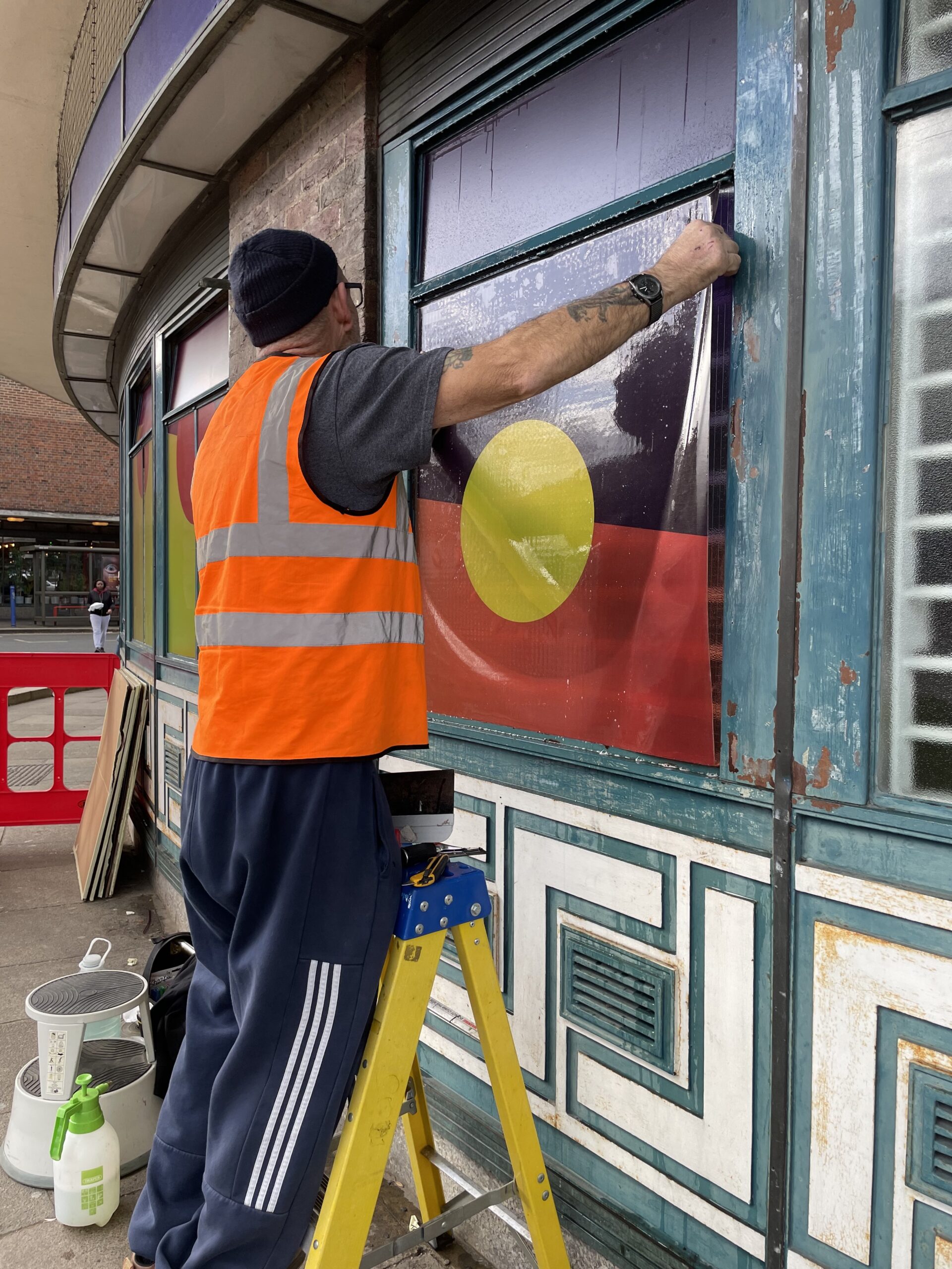 Installing window vinyl artwork on Southgate Station, London
